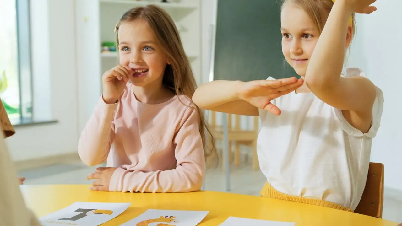 Two young children smiling and interacting in a bright and cheerful classroom setting.
